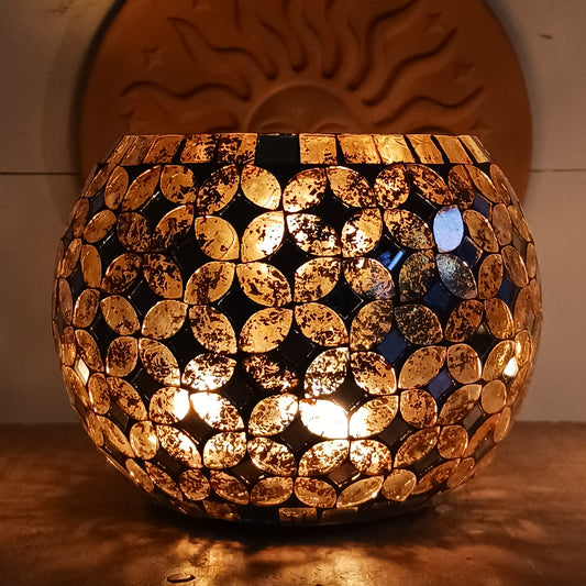 Add a warm, colourful glow to your home with this large and beautiful handmade Meena mosaic glass tealight holder, crafted by a World Fair Trade Organisation (WFTO) approved supplier in India. Featuring a distinctive retro-inspired mosaic pattern, this colourful glass candle holder makes a charming addition to a dining table, shelf, mantelpiece or cosy outdoor setting. These tealight holders are large and can accommodate 3 tealights.