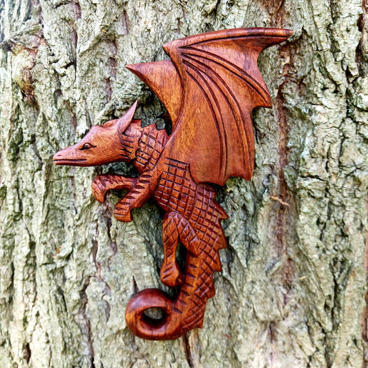 This intricately carved Dragon plaque sit flush against the wall or can be hooked onto pots or some other items in the home.  These Dragons are hand carved with metal hook for hanging if you choose.  In early cultures, the dragons were often seen as mighty serpents and beasts that were either extremely benevolent or fearsome and difficult to kill. The beliefs of a region are often influenced by geographical location. Eastern cultures often saw dragons as a knowledgeable deity that had power over storms