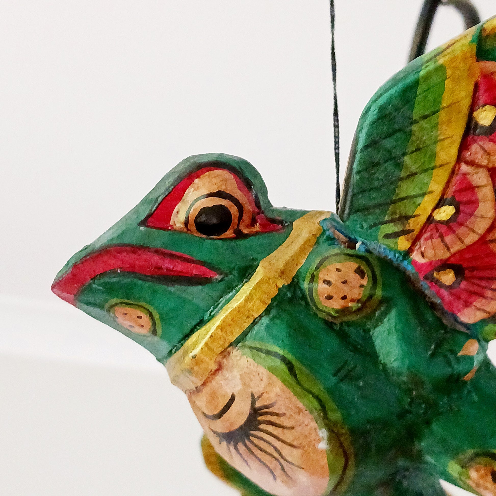 The Flying Frog Mobile is a beautiful and traditional piece of Balinese culture, featuring auspicious frogs that symbolize rain, fertility, and good fortune. Its rich colors and gold detailing make it a stunning addition to any space. Its strong twine and loop allow for easy hanging, and its winged spirit guardians are often used to ward off evil spirits in temples or homes.