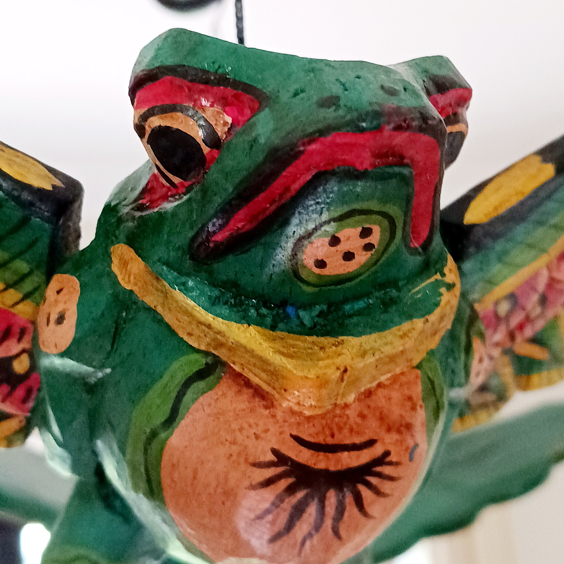 The Flying Frog Mobile is a beautiful and traditional piece of Balinese culture, featuring auspicious frogs that symbolize rain, fertility, and good fortune. Its rich colors and gold detailing make it a stunning addition to any space. Its strong twine and loop allow for easy hanging, and its winged spirit guardians are often used to ward off evil spirits in temples or homes.