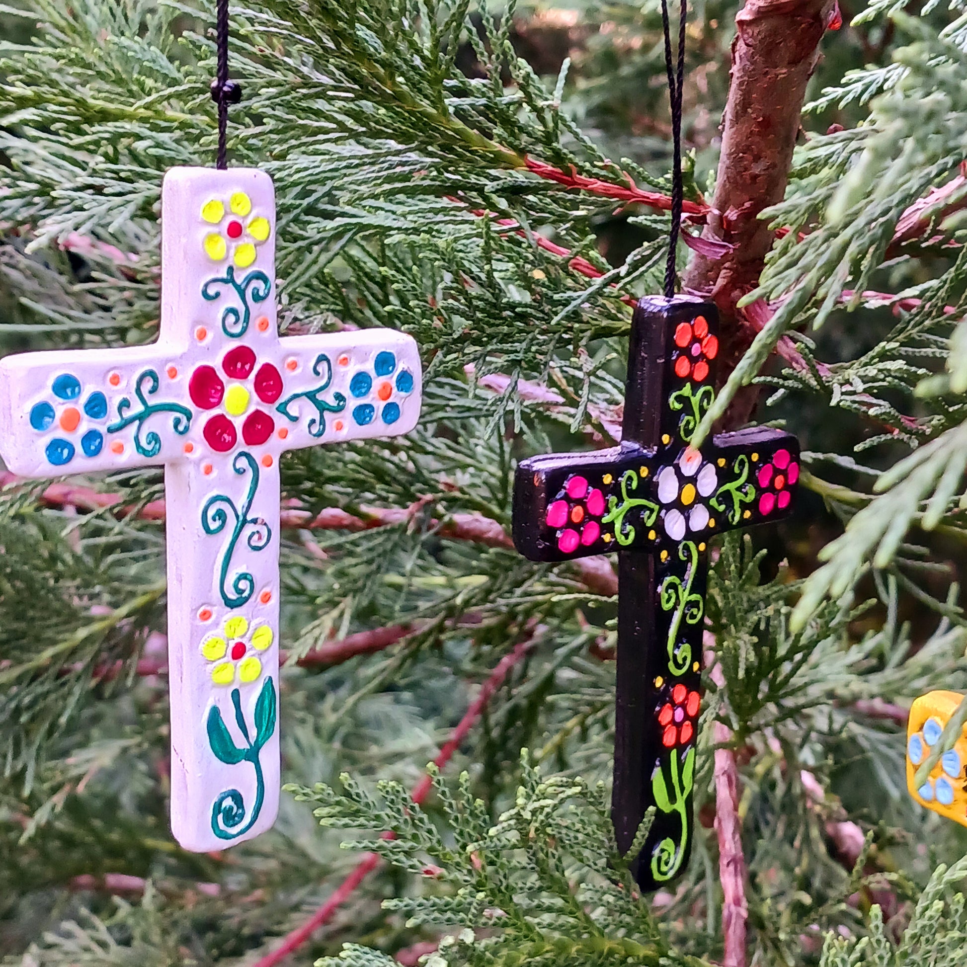 These pretty ceramic decorative crosses come in an assortment of colours with hand painted floral patterns of a traditional Peruvian style.  Each has a hanging loop allowing them to be hung at windows, on doors or as alternative Christmas tree decorations.