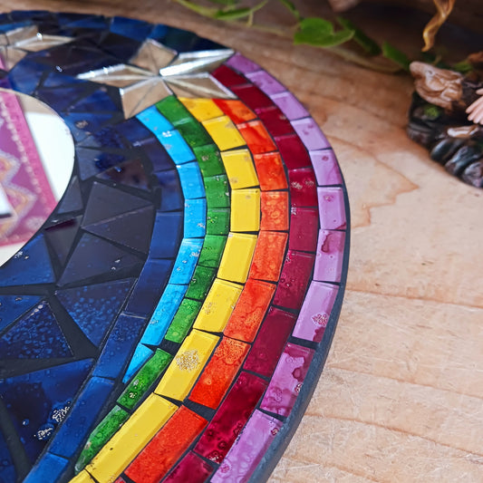 This bright and decorative round mirror is adorned with colourful mosaics creating a wonderful design of rainbow shooting stars flying through the night sky. The central area is a full mirror. Perfect to brighten up any room.