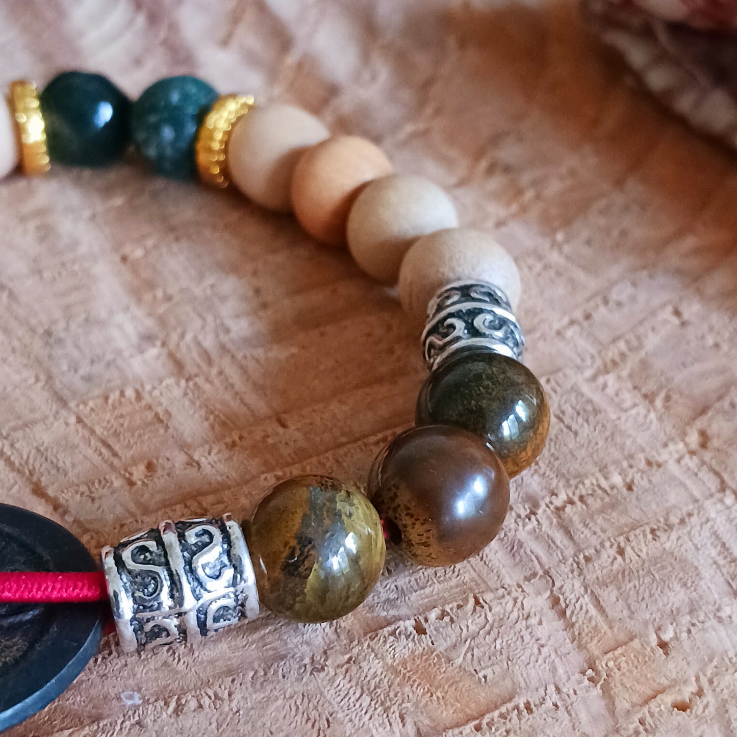 The Tri Hita Karana Power Bangles refer to the traditional philosophy of life, popular on the island of Bali, Indonesia. Tri = three, Hita = Happiness, Karana = elements.
Reincarnation or renewals means the spirit remains alive. The relationship between reincarnation and Tri Hita Karana is that all beings can harmonize their lives while in this world. So renewal and reincarnation are symbolized by the coin which meets human existence in the spiritual realm. The sandalwood beads describe human life inside t