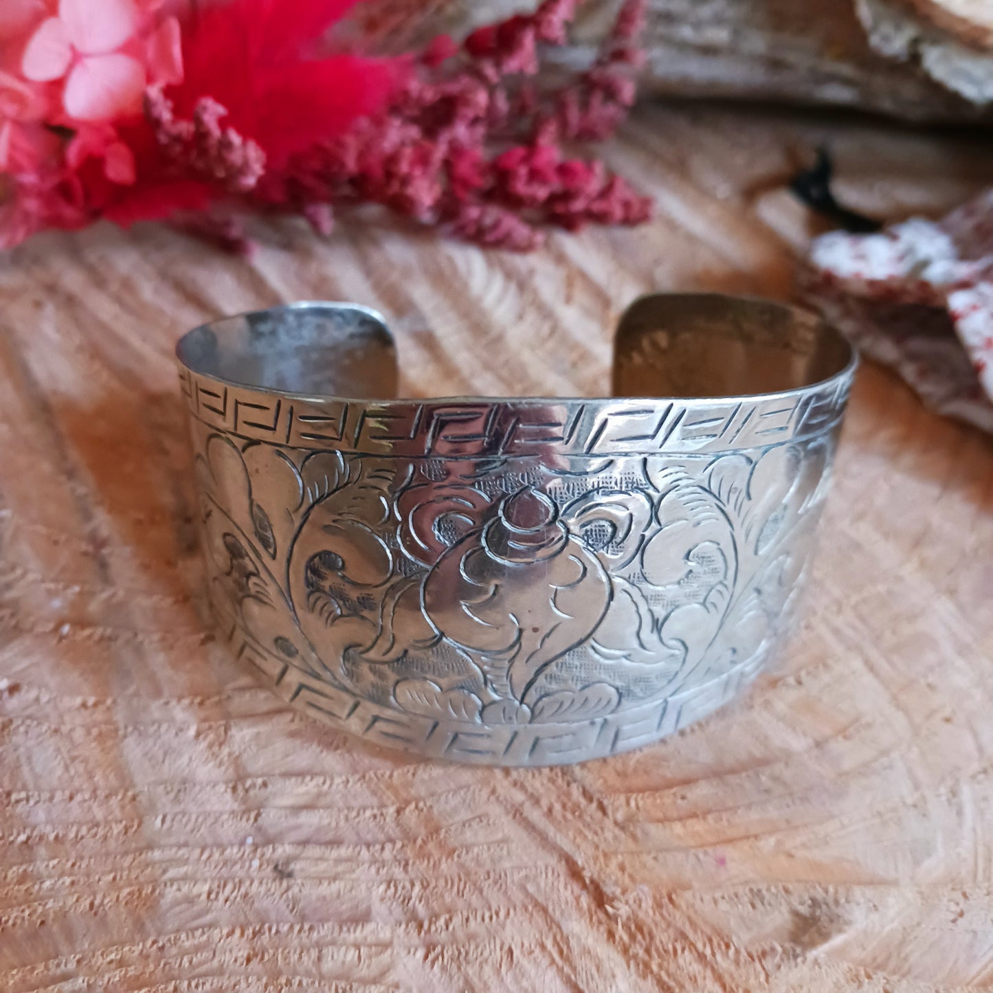Handcrafted from Tibetan white metal, this elegant bracelet is delicately hand-etched with various Buddhist symbols, including the Endless Knot.