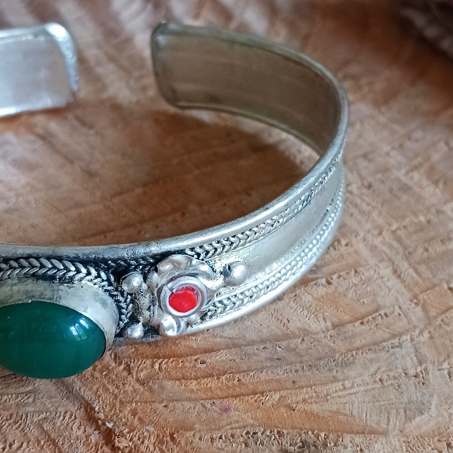 These beautifully made Nepalese white metal bangles feature a single Green Aventurine stone flanked by two red drop beads. Each bangle is soft enough to be adjusted to fit all wrist sizes.
