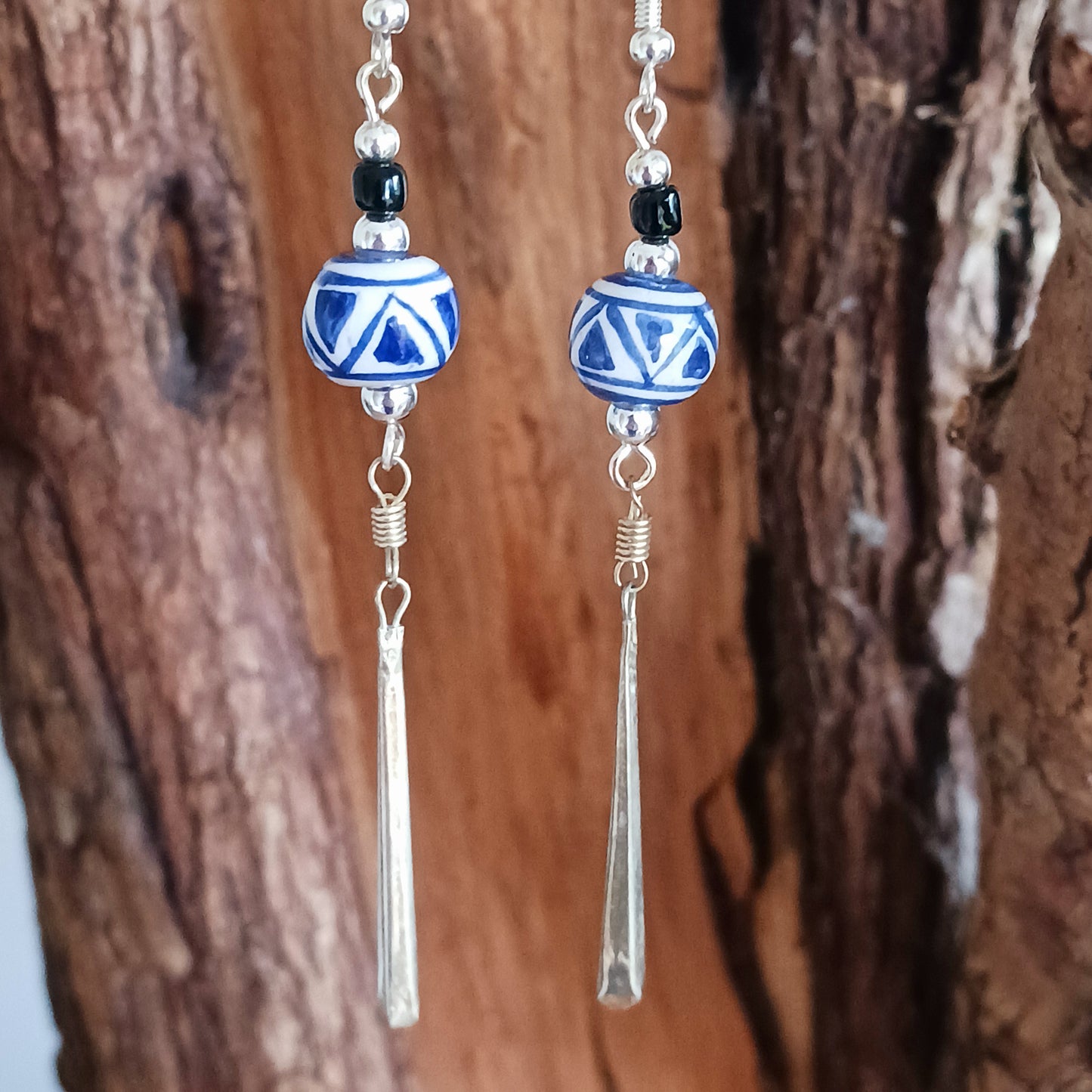 These pretty and stylish blue and white earrings have been handmade from clay beads from Cusco, Peru. Each earring features a unique hand-painted pattern that will remind of summer.