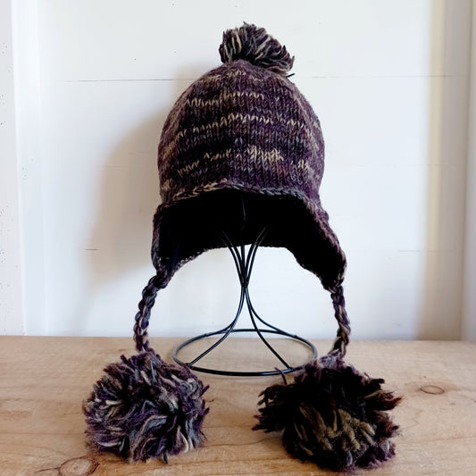 This Hasri space dye earflap hat is a fun and snuggly hat with matching pom poms. Chunky knit from tie dye wool with a smooth fleece lining so it's lovely and comfortable to wear and keep you extra warm.  Perfect for winter days out!