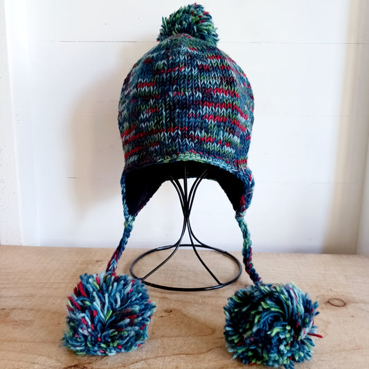 This Hasri space dye earflap hat is a fun and snuggly hat with matching pom poms.  Chunky knit from tie dye wool with a smooth fleece lining so it's lovely and comfortable to wear and keep you extra warm. Perfect for winter days out!