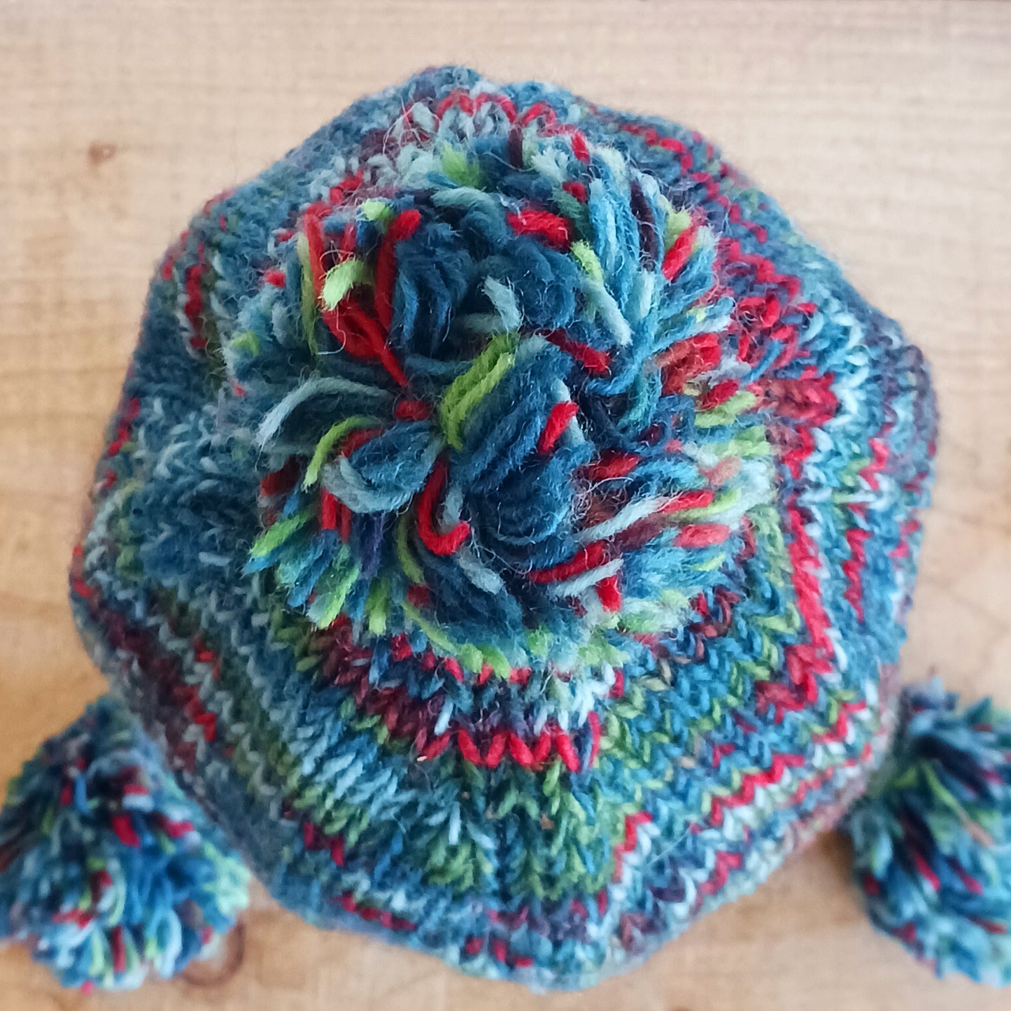 This Hasri space dye earflap hat is a fun and snuggly hat with matching pom poms. Chunky knit from tie dye wool with a smooth fleece lining so it's lovely and comfortable to wear and keep you extra warm. Perfect for winter days out!