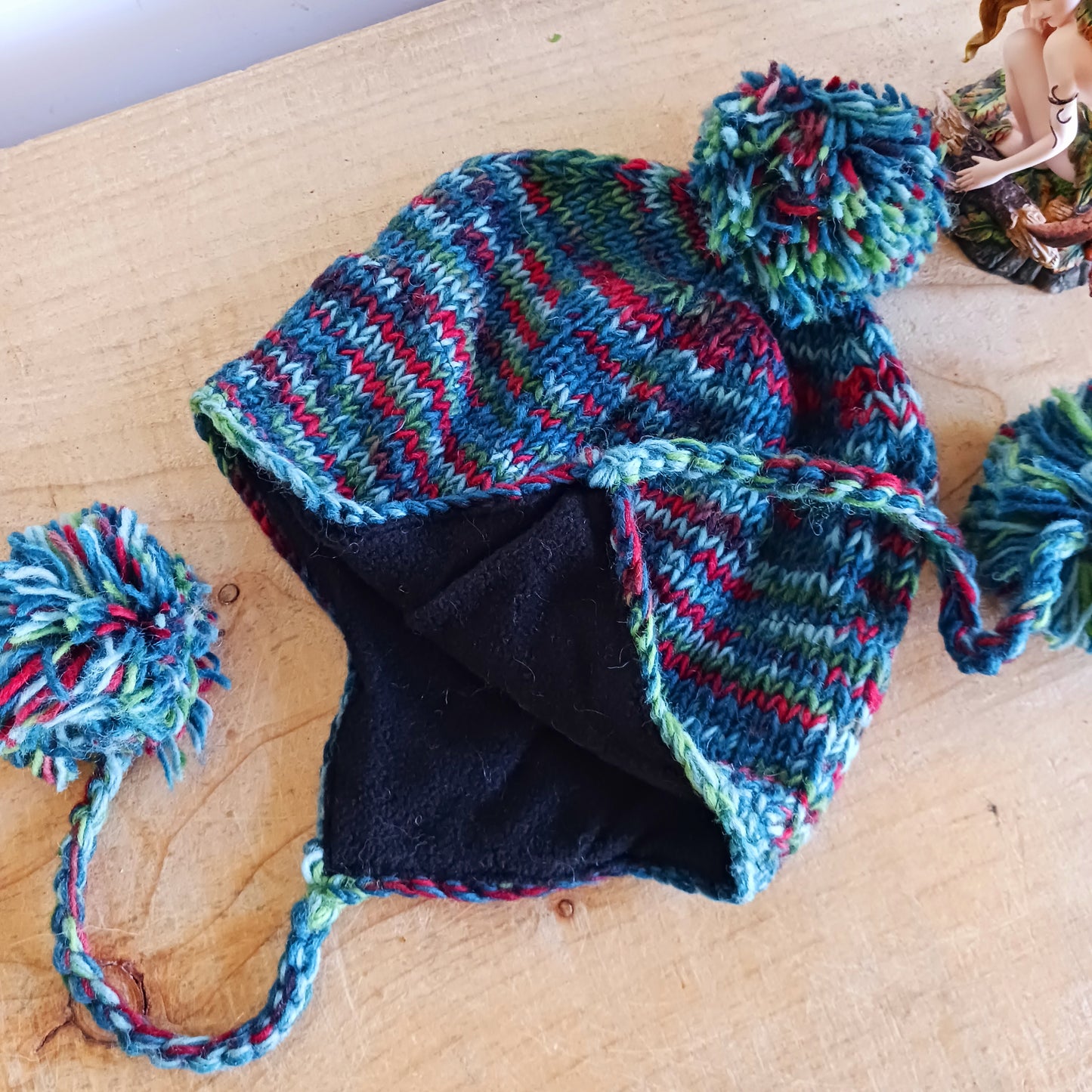 This Hasri space dye earflap hat is a fun and snuggly hat with matching pom poms. Chunky knit from tie dye wool with a smooth fleece lining so it's lovely and comfortable to wear and keep you extra warm. Perfect for winter days out!