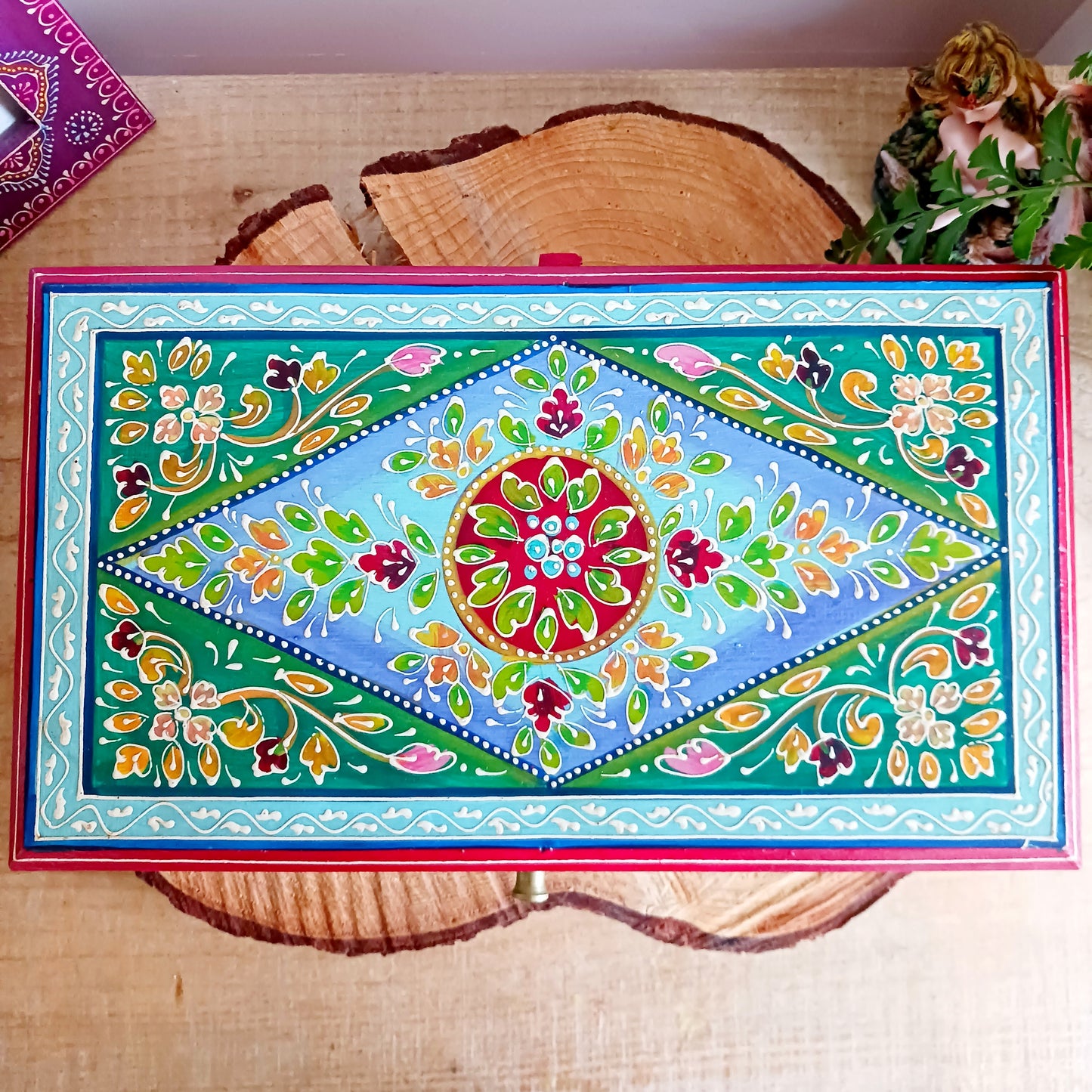 This is a large and beautiful hand made, hand painted Indian wooden jewellery box in a striking turquoise and floral pattern. The box has a hinged lid and front closure. Ideal as a decorative jewellery, trinket, keepsake box or a tidy, attractive way of hiding odds and ends.