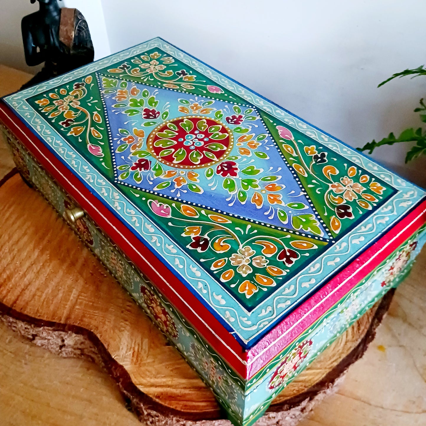 This is a large and beautiful hand made, hand painted Indian wooden jewellery box in a striking turquoise and floral pattern. The box has a hinged lid and front closure. Ideal as a decorative jewellery, trinket, keepsake box or a tidy, attractive way of hiding odds and ends.