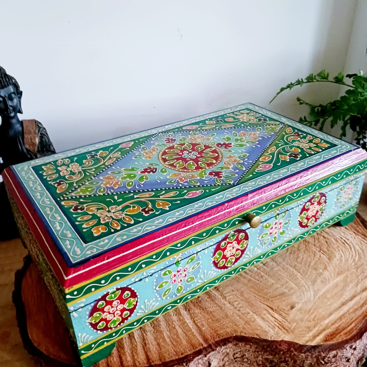 This is a large and beautiful hand made, hand painted Indian wooden jewellery box in a striking turquoise and floral pattern. The box has a hinged lid and front closure. Ideal as a decorative jewellery, trinket, keepsake box or a tidy, attractive way of hiding odds and ends.