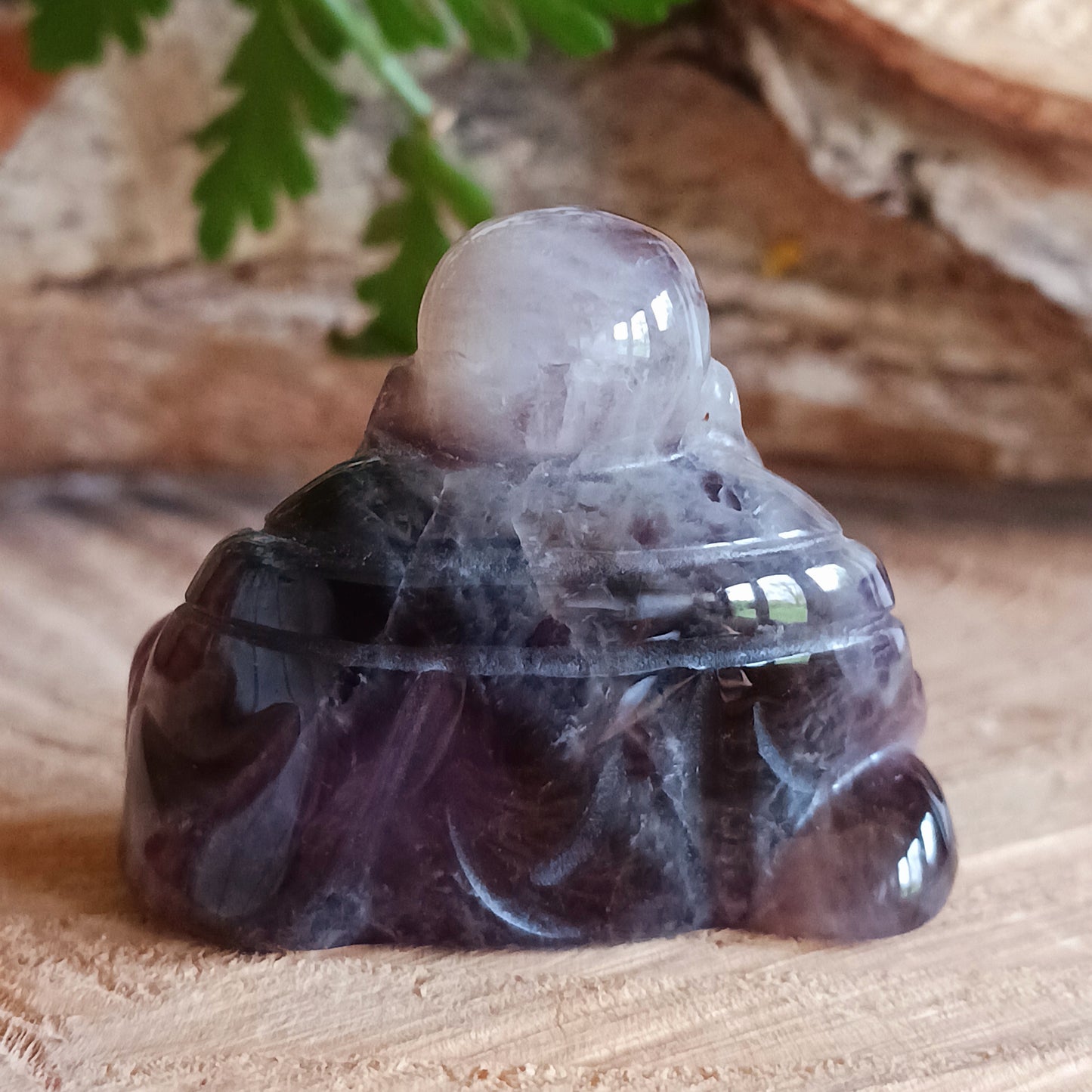 This beautiful miniature handcarved Laughing Buddha has been crafted from genuine Amethyst. This gemstone Buddha is a jolly and elegant symbol of peace, spiritual growth, and inner clarity.