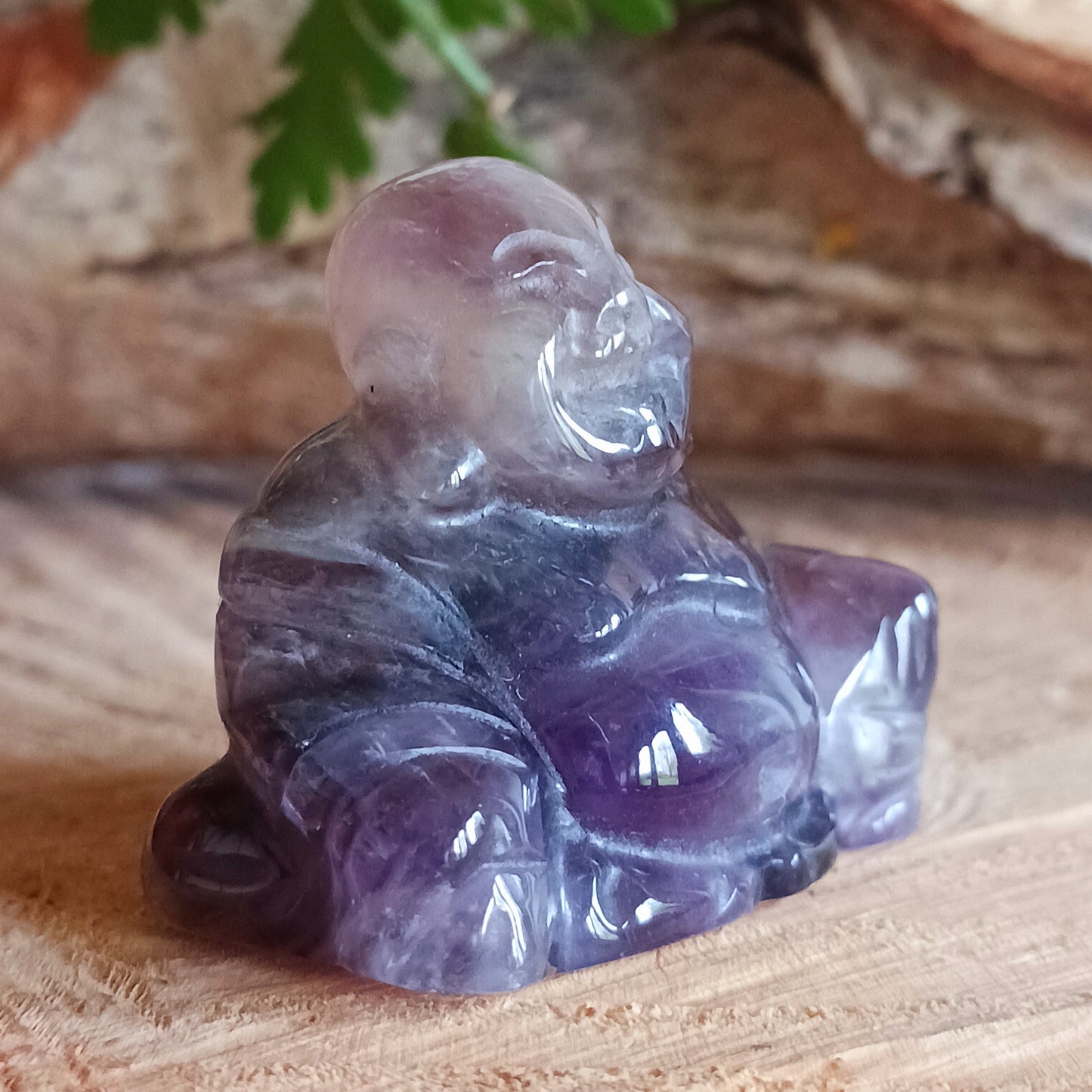 This beautiful miniature handcarved Laughing Buddha has been crafted from genuine Amethyst. This gemstone Buddha is a jolly and elegant symbol of peace, spiritual growth, and inner clarity.