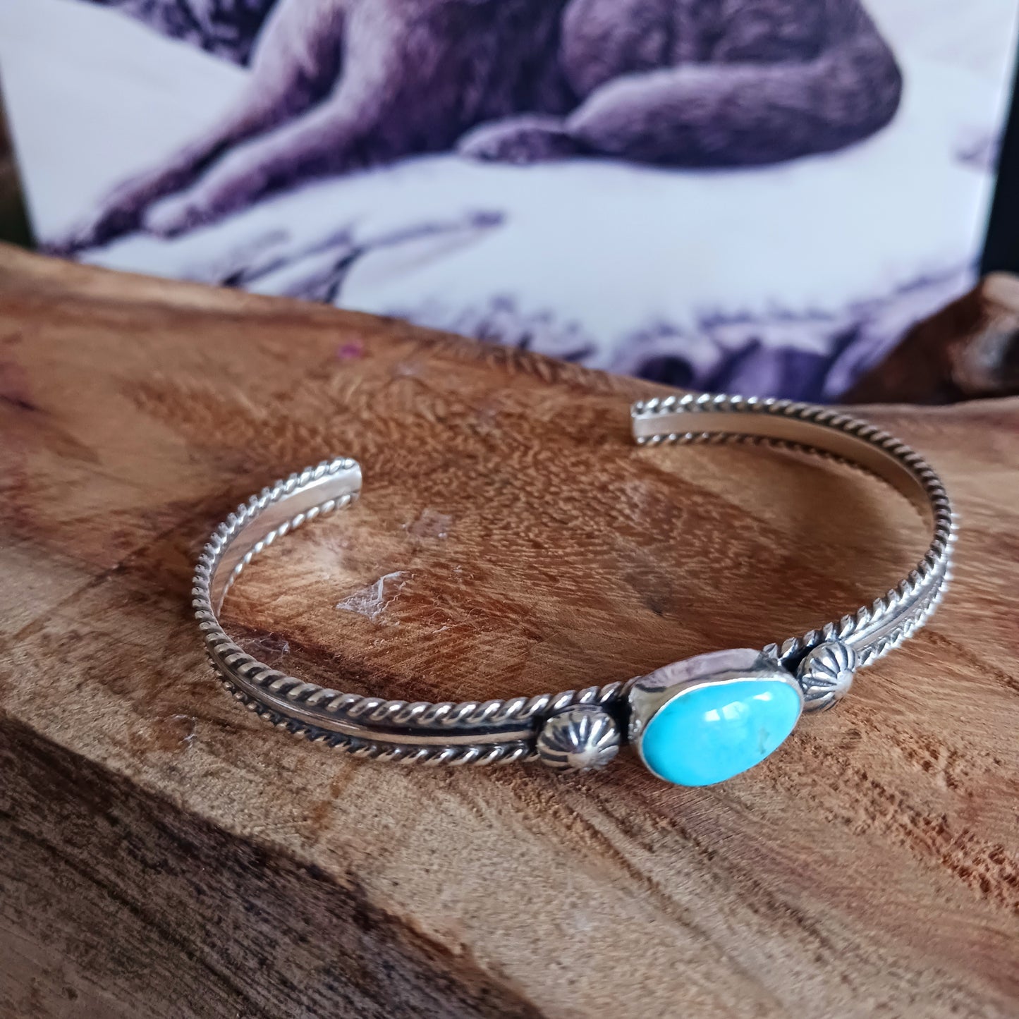This beautiful and elegant Kingman Turquoise bracelet has been handmade by Navajo artisan Ben Jimenez. The finely crafted silver band is complemented by a stunning Turquoise stone at the centre. This is the artistry of Ben Jimenez who has developed such a distinctive style.