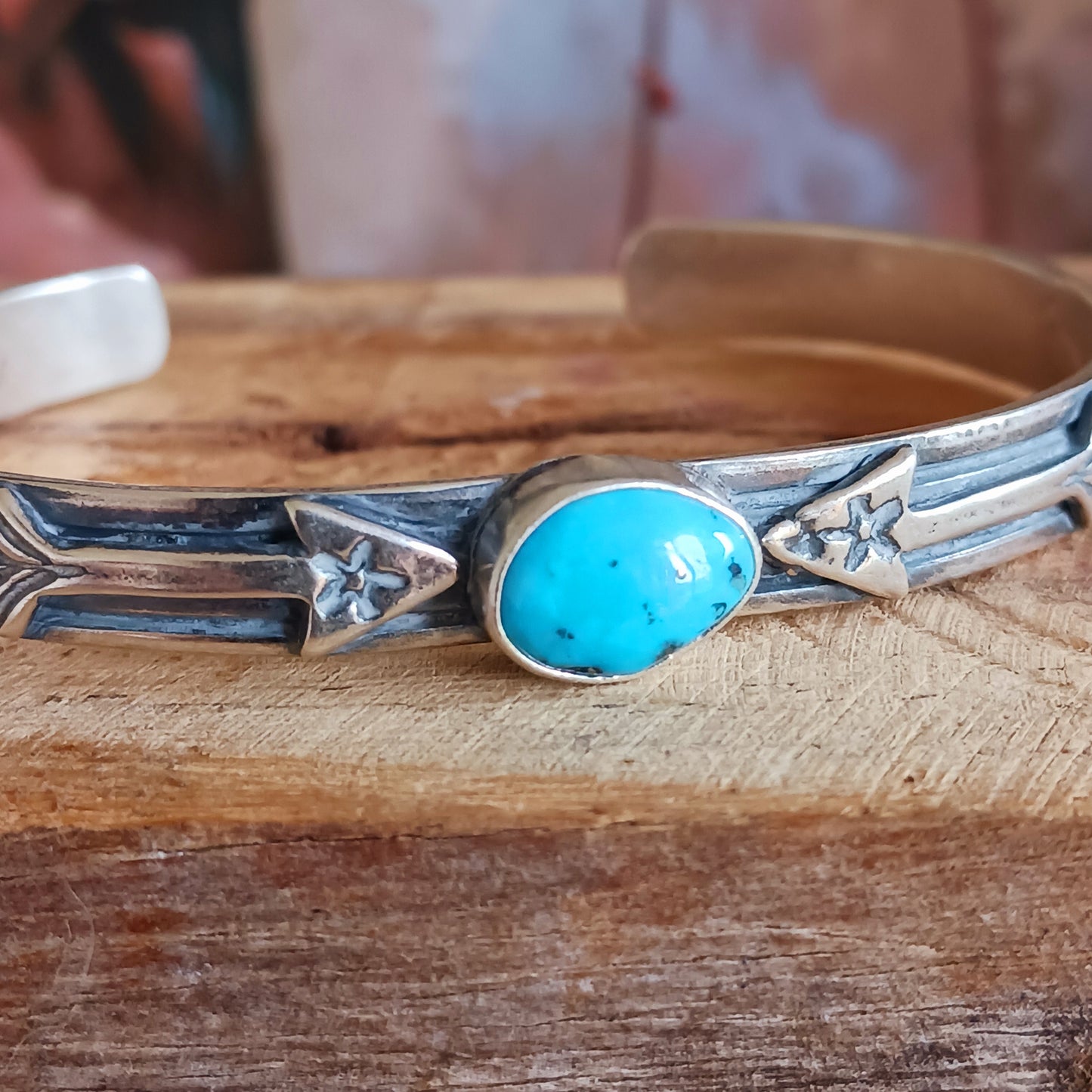 This bracelet is a stunning example of classic Navajo jewellery. This piece is handmade out of sterling silver and genuine Turquoise oval stone. The Arrows are for protection.