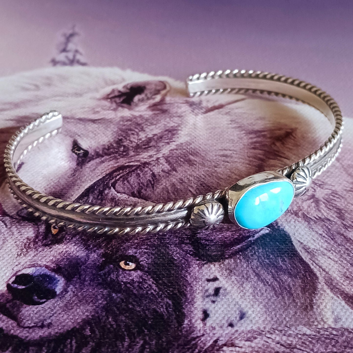 This beautiful and elegant Kingman Turquoise bracelet has been handmade by Navajo artisan Ben Jimenez. The finely crafted silver band is complemented by a stunning Turquoise stone at the centre. This is the artistry of Ben Jimenez who has developed such a distinctive style.