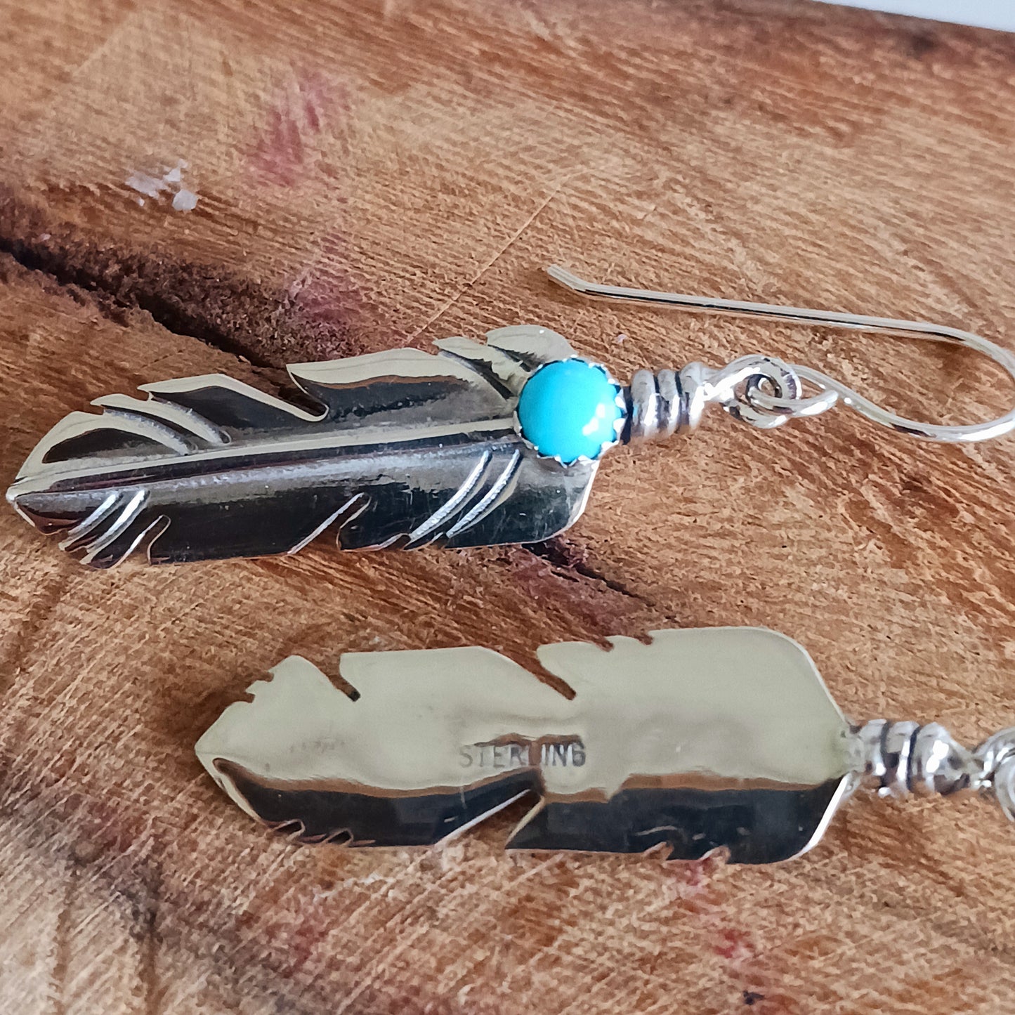 These are exquisite Navajo solid silver earrings, handmade by Navajo artist, Lula Nez. The feather earrings are hand cut with natural Kingsman Turquoise stone. Feather is a totem of the all-powerful eagle and a gift of feather is a great honour.