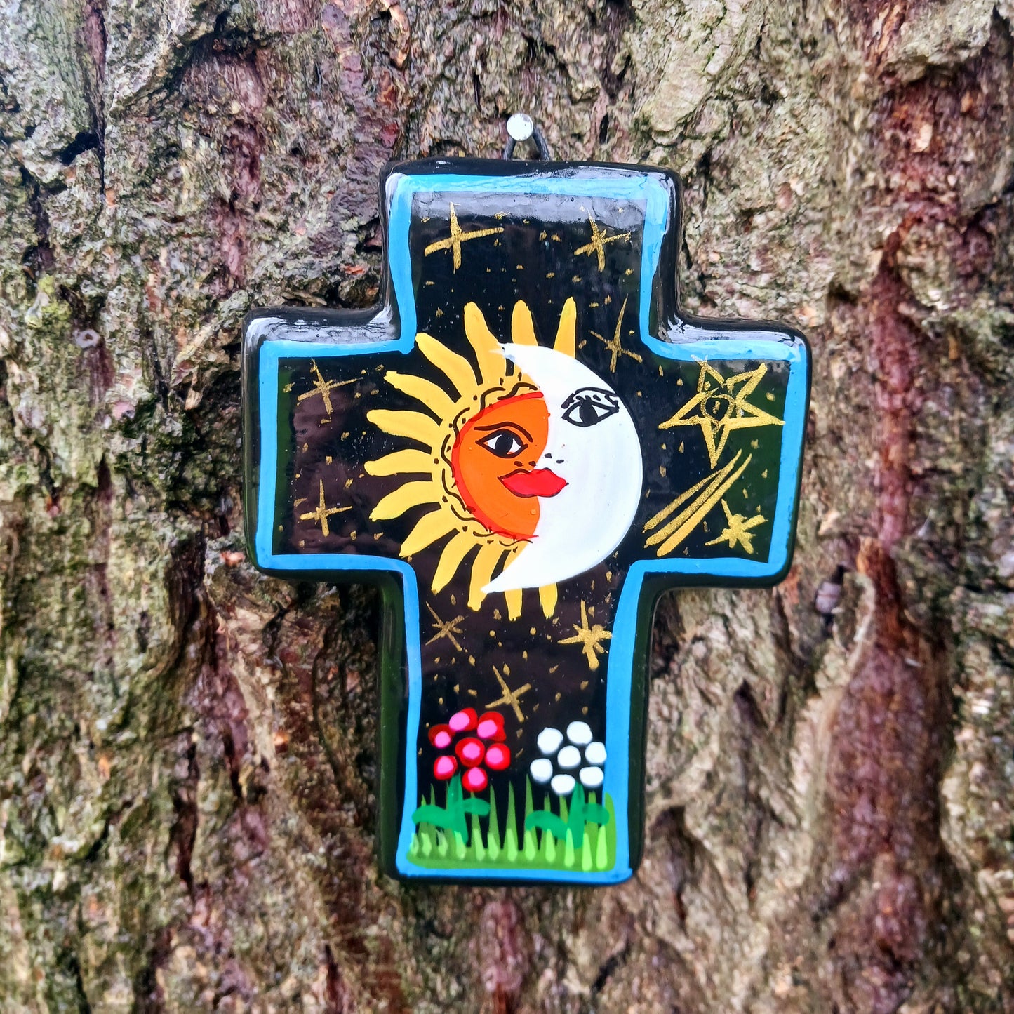 This bold handpainted Mexican cross has a striking glaze to further enhance the vibrant design of a solar and lunar eclipse.