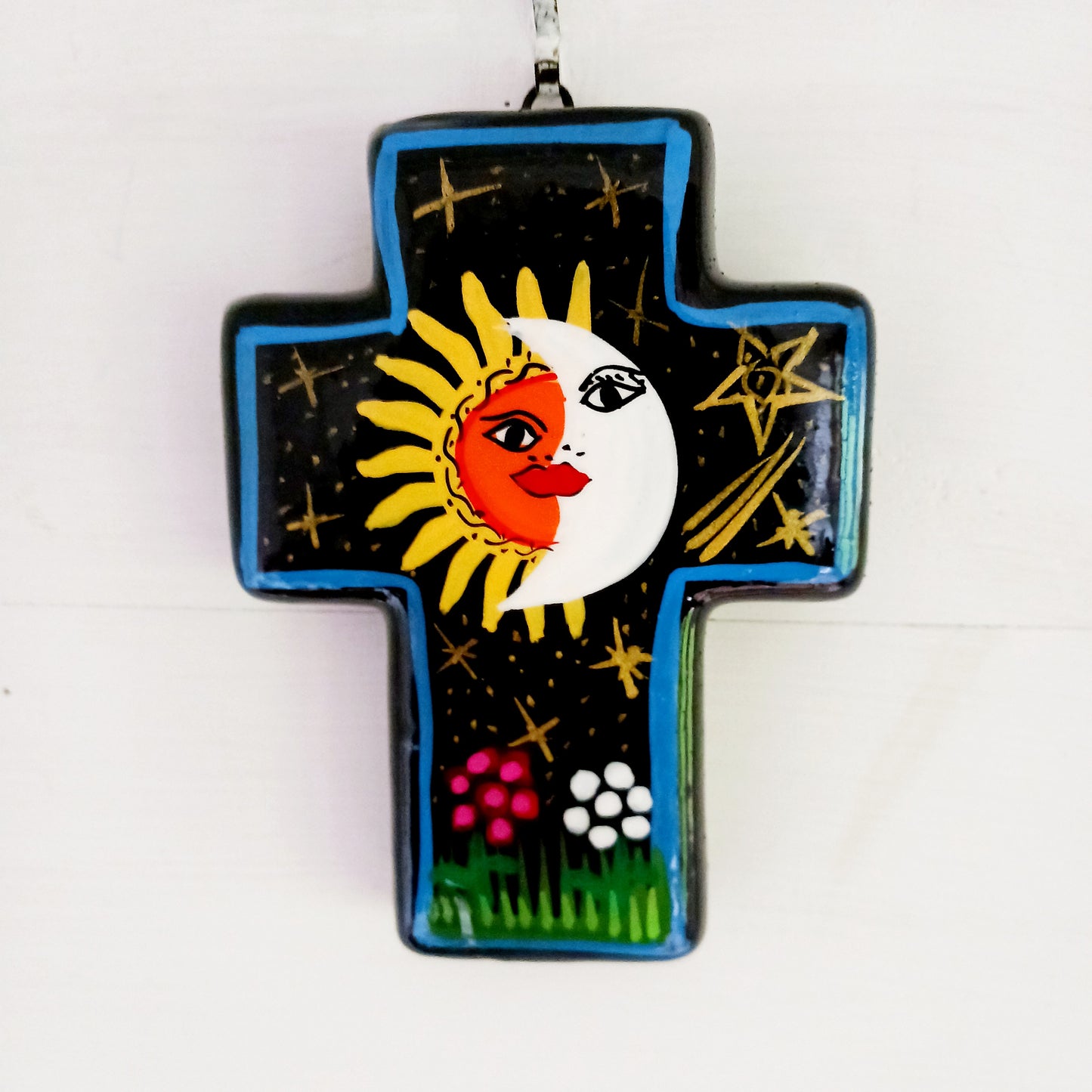 This bold handpainted Mexican cross has a striking glaze to further enhance the vibrant design of a solar and lunar eclipse.