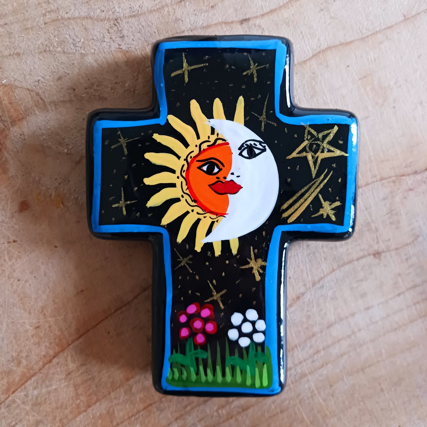 This bold handpainted Mexican cross has a striking glaze to further enhance the vibrant design of a solar and lunar eclipse.