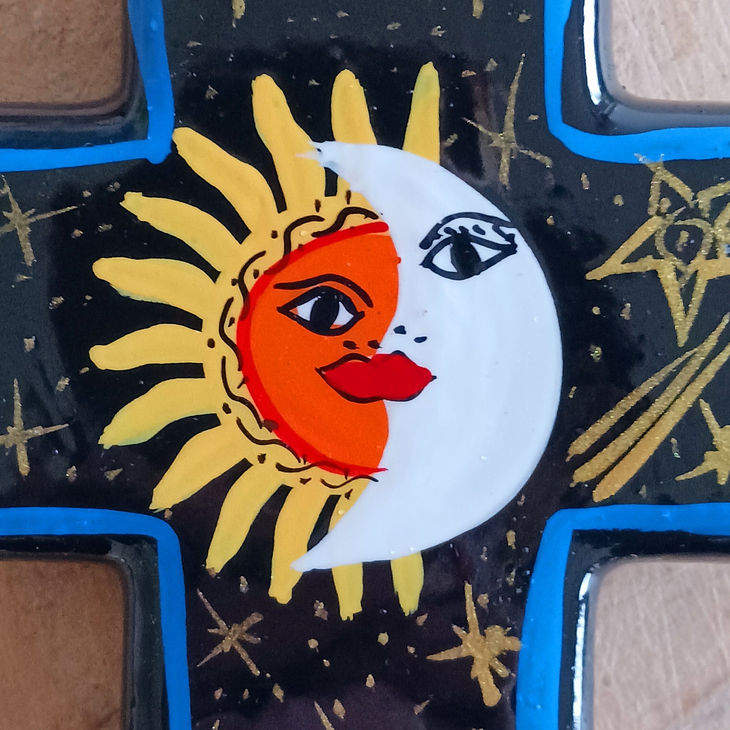 This bold handpainted Mexican cross has a striking glaze to further enhance the vibrant design of a solar and lunar eclipse.