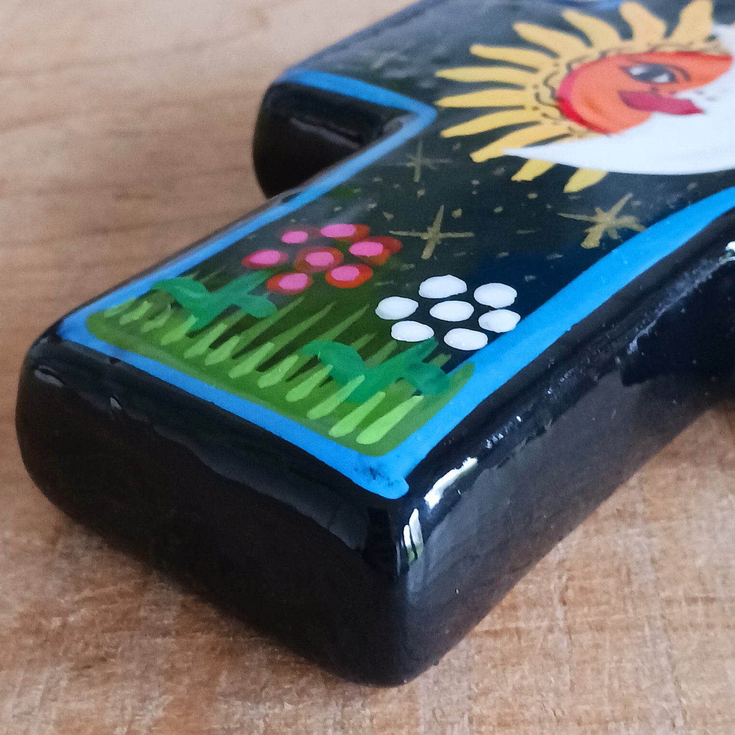This bold handpainted Mexican cross has a striking glaze to further enhance the vibrant design of a solar and lunar eclipse.