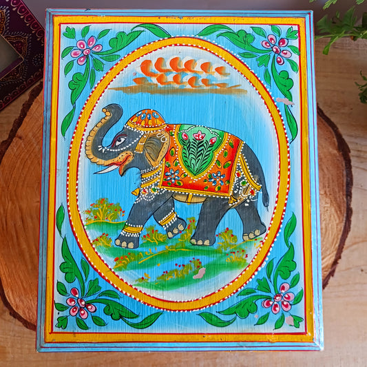 This stunning large Indian jewellery box has been hand painted to perfection in fresh spring-like colours of pastel blue, primrose yellow, pale pink and new season green.  The elephant on the lid is in full ceremonial regalia and oval framed in yellow. It comprises a single drawer and top compartment opened by discreet round knobs.  A beautiful addition to any home.
