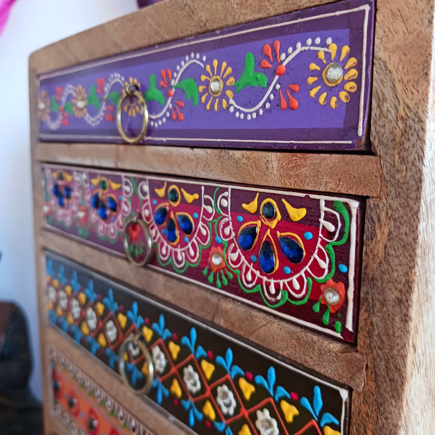 The Hindi word 'Sankalaka' is translated as 'eclectic'. The random applicaton of skillfully painted drawer panels results in this beautiful, eclectic, unique 6-drawer chest. Each panel is hand painted to perfection by highly skilled artisans. A beautiful addition to any home.