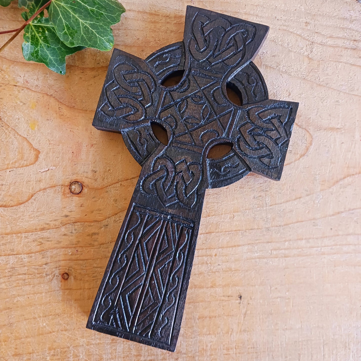 This detailed and lightweight wooden carved Celtic cross is a lovely little piece that has carvings featuring Celtic style knots and etchings.