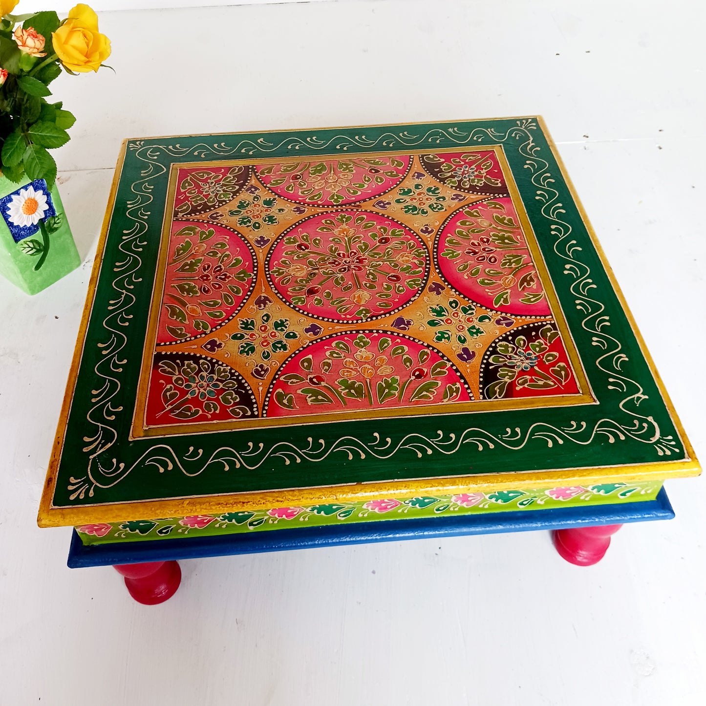 Bring a touch of Indian vibrance to your home with this stunning hand-painted pink and lime bajot table. Hand crafted from solid wood and decorated with eye-catching Indian motifs, this lovely piece of furniture makes a charming coffee table or unique accent piece.