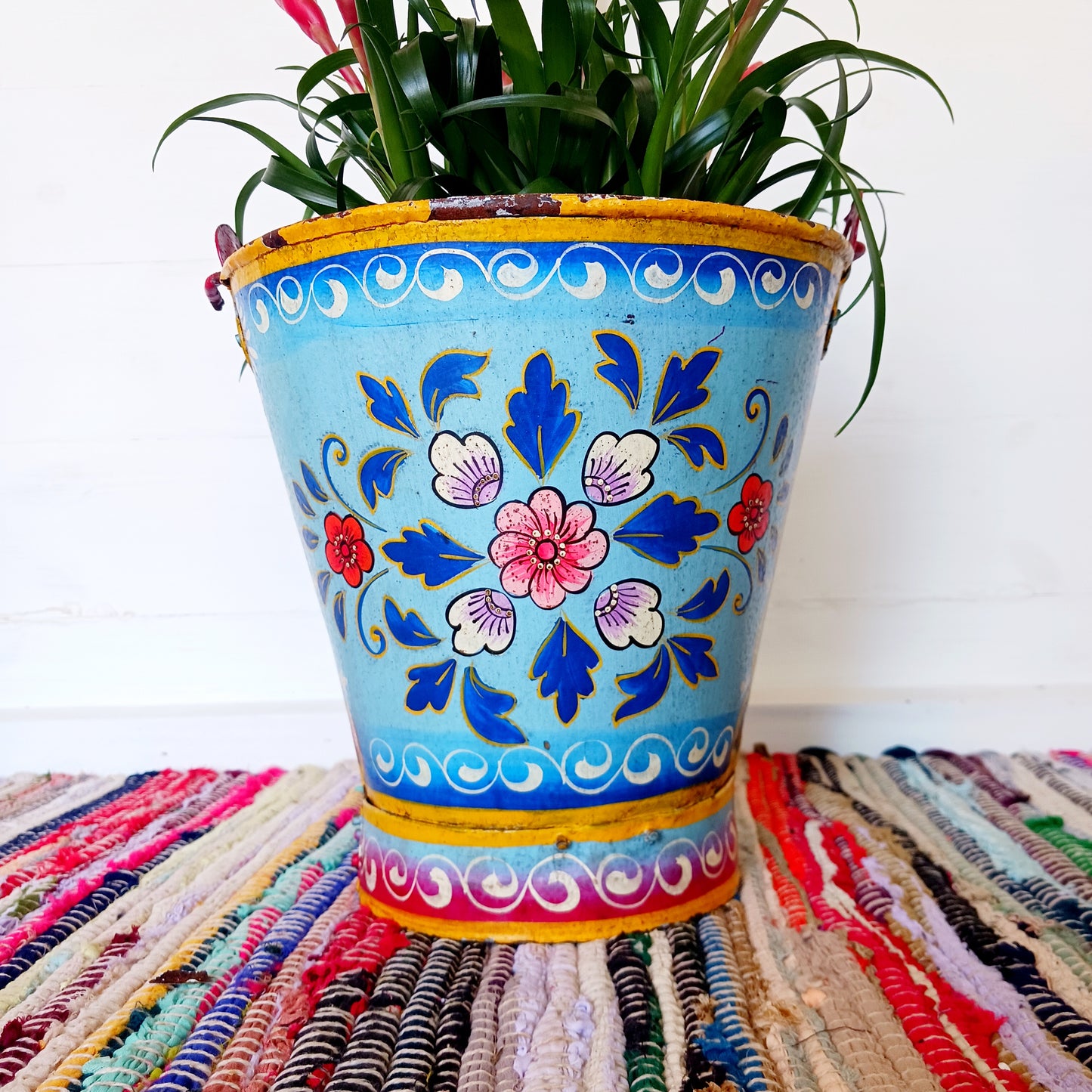 Hand painted in a blue floral design, a vintage style iron plant pot to display as a decorative indoor/outdoor planter.
Lovingly hand painted by skilled artisans on a fair trade basis in the Indian desert city of Jodhpur. Fill the striking container with a flowering or contrasting potted plant. Grow seasonal bulbs to bring life and inspiration.