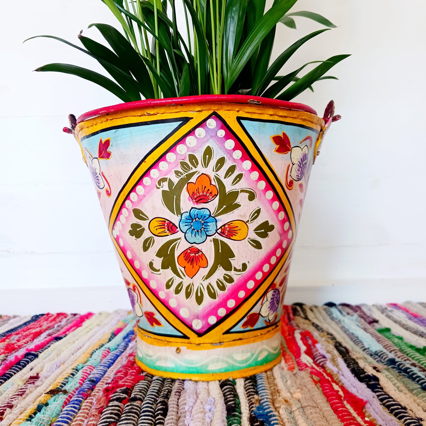 Hand painted in a pink floral design, a vintage style iron plant pot to display as a decorative indoor/outdoor planter.
Lovingly hand painted by skilled artisans on a fair trade basis in the Indian desert city of Jodhpur. Fill the striking container with a flowering or contrasting potted plant. Grow seasonal bulbs to bring life and inspiration.