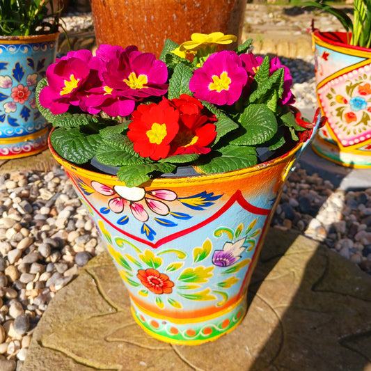 Hand painted in a turquoise floral design, a vintage style iron plant pot to display as a decorative indoor/outdoor planter. Lovingly hand painted by skilled artisans on a fair trade basis in the Indian desert city of Jodhpur. Fill the striking container with a flowering or contrasting potted plant. Grow seasonal bulbs to bring life and inspiration.