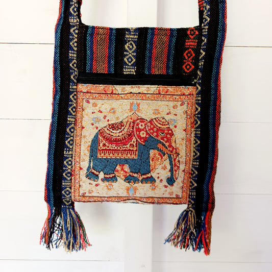 his handy little shoulder bag has a wide strap that is long enough to use as a shoulder or crossbody bag and also makes it comfortable to wear for long periods. The main fabric is traditional with a beautiful embroidered elephant design on the front. The bag is finished with tassels.