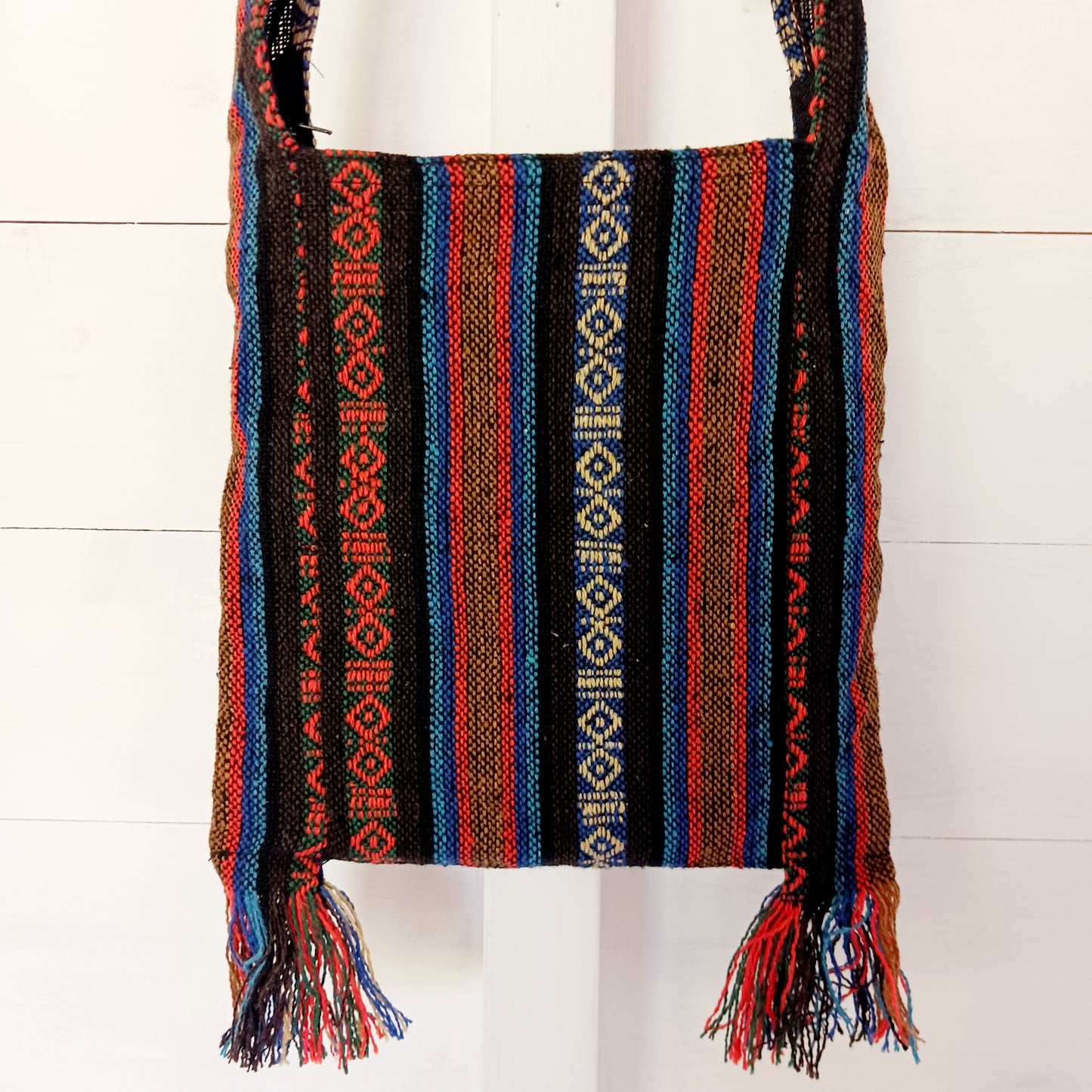 his handy little shoulder bag has a wide strap that is long enough to use as a shoulder or crossbody bag and also makes it comfortable to wear for long periods. The main fabric is traditional with a beautiful embroidered elephant design on the front. The bag is finished with tassels.