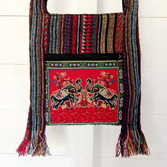 This handy little shoulder bag has a wide strap that is long enough to use as a shoulder or crossbody bag and also makes it comfortable to wear for long periods. The main fabric is traditional with a beautiful embroidered decorated elephants on the front. The bag is finished with tassels.