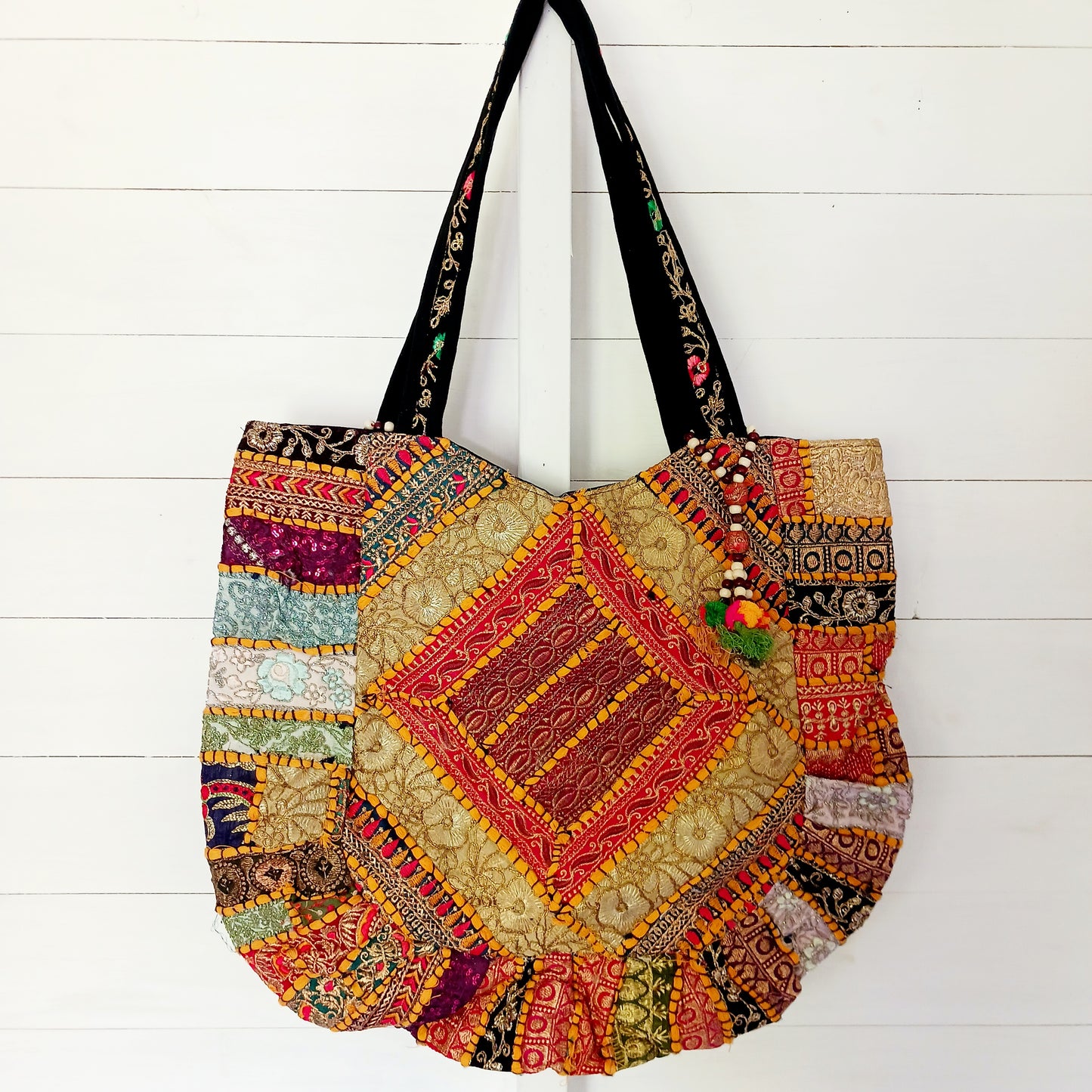 This beautiful large Indian tote bag comes with a wide shoulder strap and plenty of space inside for your personal items. In a patchwork style design, this bag is intricately embroidered with a traditional bohemian pattern.The bag comes decorated with beads and pom poms and is fully lined throughout.
