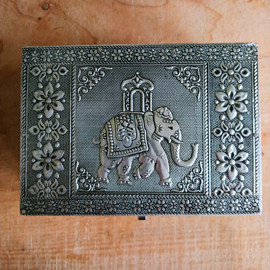 Elevate your jewellery storage with this exquisite silver-coloured aluminium jewellery box, beautifully embossed with an elephant carrying a howdah and framed by intricate borders. Lined with soft cotton velvet, it offers a luxurious feel while protecting your precious pieces.