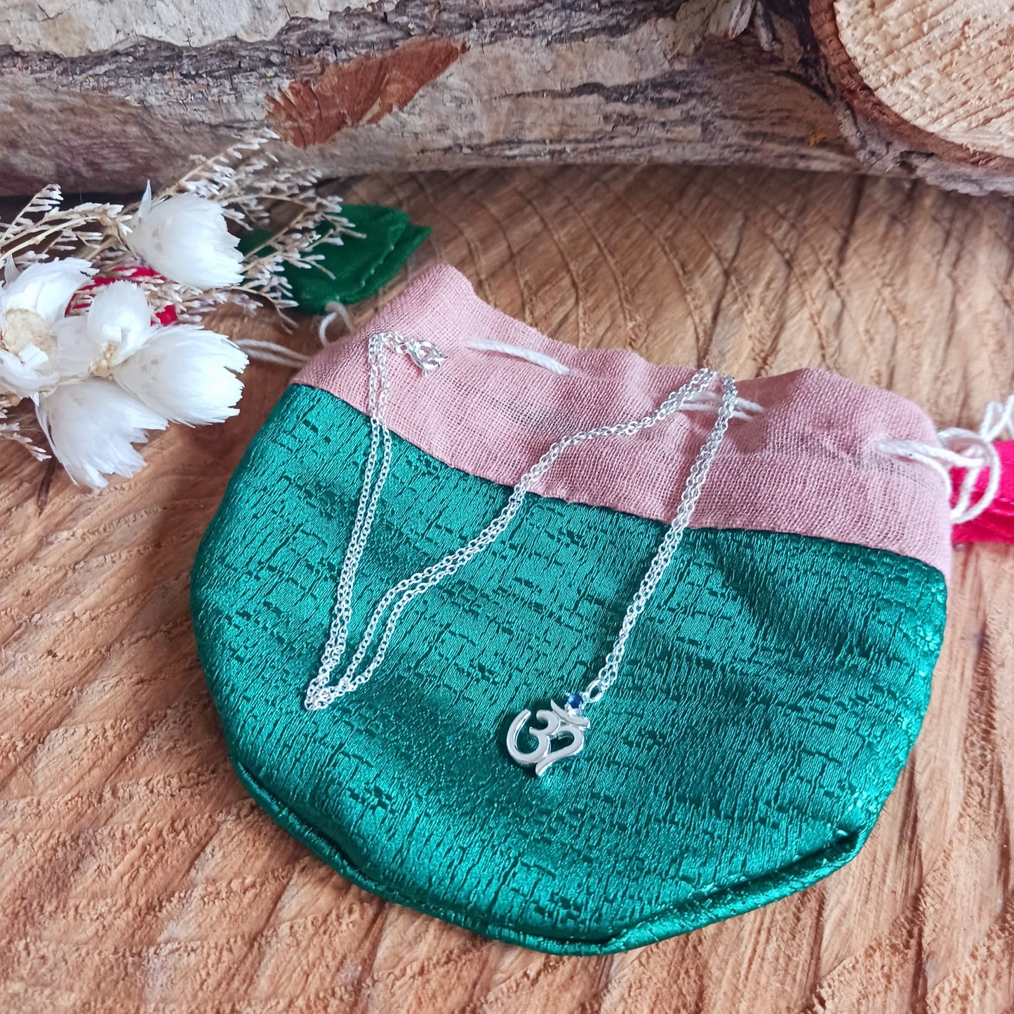 This lovely Om Symbol silver pendant is very dainty and comes with an inlaid Corundum blue stone, on a fine solid 925 silver chain. Om or (Aum) is a sacred sound considered by many ancient philosophical texts to be the sound of the universe, encompassing all other sounds within it. In Sanskrit, om is called Pranava, which means to hum, and is considered an unlimited or eternal sound.