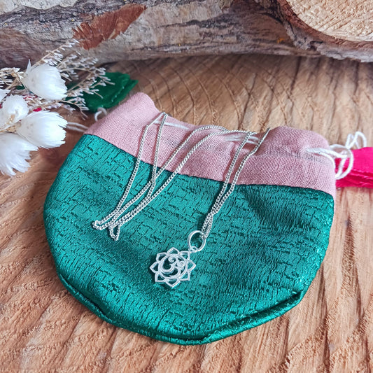 This lovely Om Symbol in Lotus silver pendant has a tiny embedded zirconia stone and comes with a fine solid 925 silver chain. Om or (Aum) is a sacred sound considered by many ancient philosophical texts to be the sound of the universe, encompassing all other sounds within it. In Sanskrit, om is called Pranava, which means to hum, and is considered an unlimited or eternal sound.