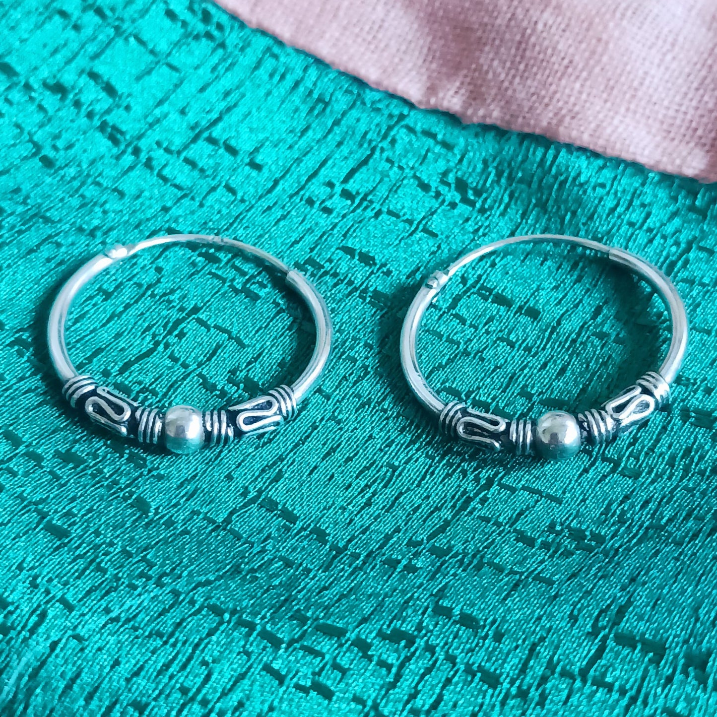 These sterling silver hoop earrings are made in a Bali style. With a silver ball in the middle of the hoop earrings, these 925 silver earrings make an ideal choice for any boho look.
