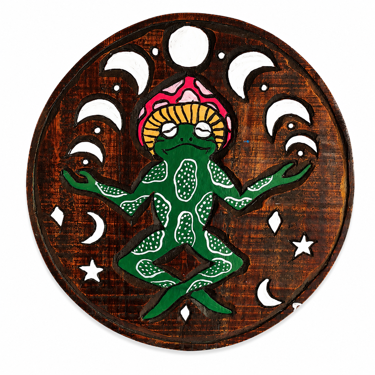 Hand Carved Meditating Frog Wall Plaque displayed in a vibrant boho-inspired living room. The round wooden wall hanging features a green frog in a lotus meditation pose beneath moon phases and celestial symbols. Measuring approximately 33cm x 34cm, the plaque is shown to scale on a wall surrounded by colourful psychedelic artwork, lush houseplants, macramé décor, a lava lamp, vinyl records, and warm ambient lighting. The eclectic hippie-style interior creates a groovy, spiritual atmosphere perfect for medit
