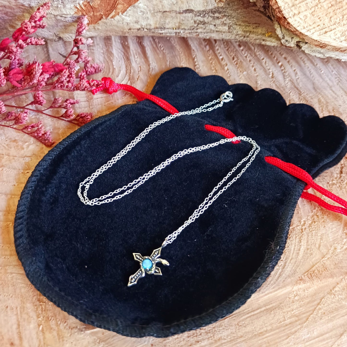This detailed sterling silver cross has a silver serpent wrapped around it and comes with a beautiful Azure stone in the centre. The cross is held on a 925 silver chain. The snake is thought to represent transformation and rebirth, symbolizing the shedding of old skin and embracing new beginnings. The cross, a powerful symbol of faith and spirituality, adds an element of devotion and divine connection to the design.