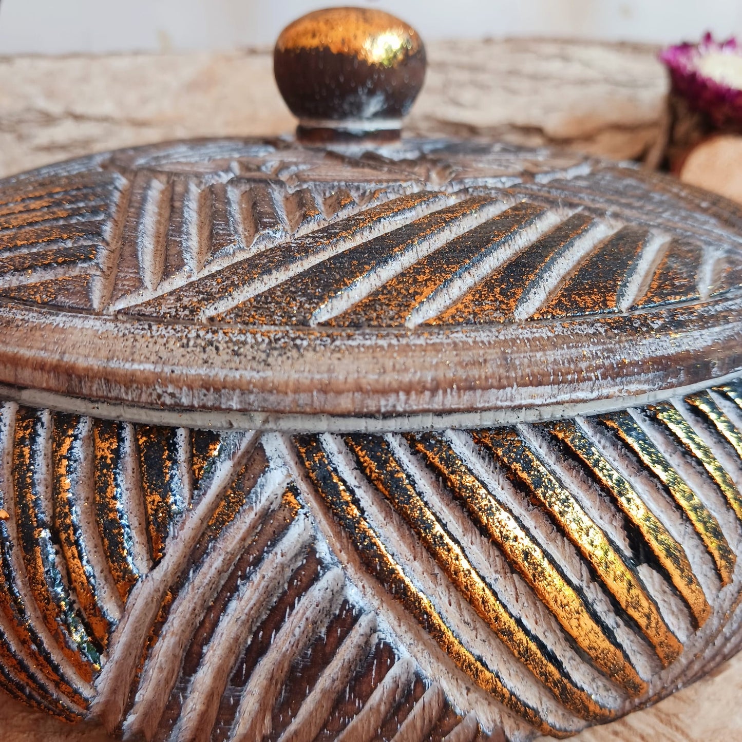 This exquisite box is not only a storage solution but also a work of art, designed to add a touch of luxury to any space. The wooden box is jar shaped and features an elegant design that evokes a sense of timeless beauty. The dazzling gold glitter embellishment on natural wood creates a mesmerizing interplay of colours, catching the light and infusing the surroundings with a sense of grandeur.