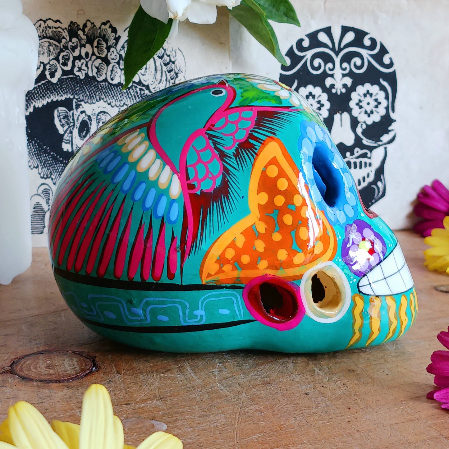 These fun ceramic sugar skull ornaments have been beautifully painted in bright colours and finished with a high shine glaze. They are a popular item during Día de Los Muertos or Day of the Dead festivities, held in Mexico every November to celebrate welcoming the souls of their deceased relatives back for a time of food, drink and celebration.