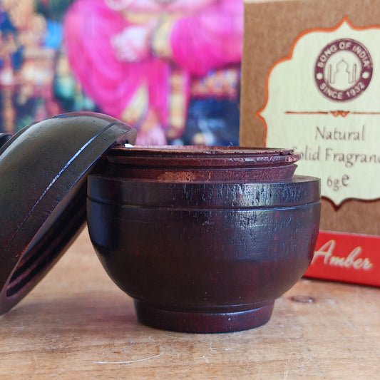 Experience the timeless beauty of jasmine with this luxurious Song of India Amber Fragrance Cream, beautifully housed in a handcrafted rosewood jar. Made by skilled artisans using carefully selected Indian rosewood bark, each container showcases unique natural grain patterns, colours, and veins, making every piece a one-of-a-kind collectible.