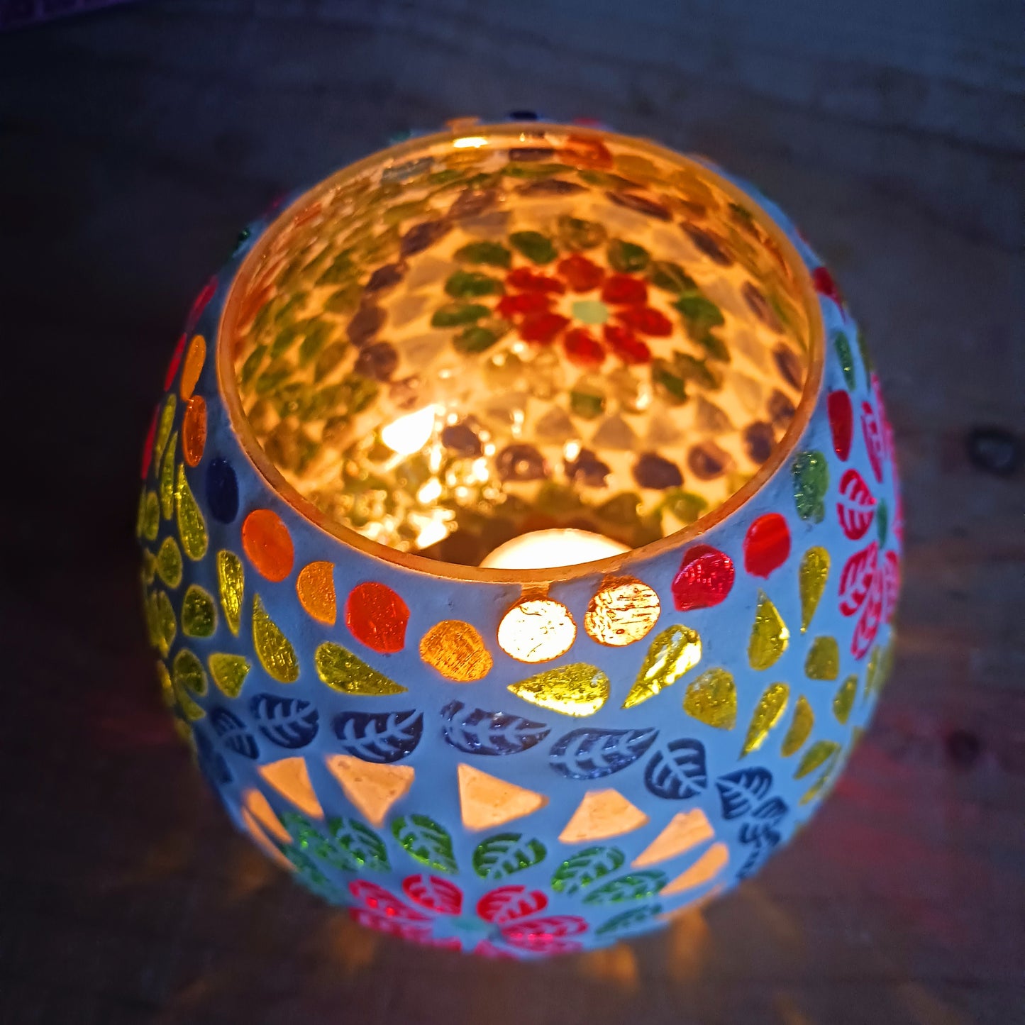 These beautiful tealight holders are a mosaic mixture of pearlescent and block colours that create a vibrant floral mandala design on this glass tealight holder. Pop in a lit tealight to warm the atmosphere with multi colour vibes on outdoor summer evenings, or indoors to brighten the long dark evenings.