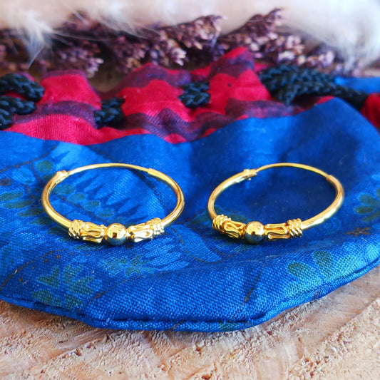 These sterling silver gold plate hoop earrings are made in a Bali style. With a silver ball in the middle of the hoop earrings, these 925 silver earrings make an ideal choice for any boho look.